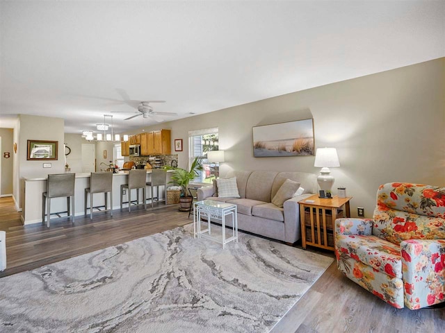 1564 Emerald Ct Unit 85, Petoskey, MI 49770 - living room featuring wood finished floors, a ceiling fan, baseboards, and a chandelier