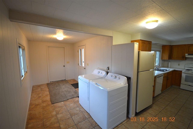 409 Trent St, Boyne City, MI 49712 - kitchen with white appliances, washing machine and clothes dryer, range hood, brown cabinets, and light countertops