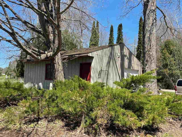 9690 Lake St, Ellsworth, MI 49729 - view of property exterior with a garage, an outdoor structure, and board and batten siding