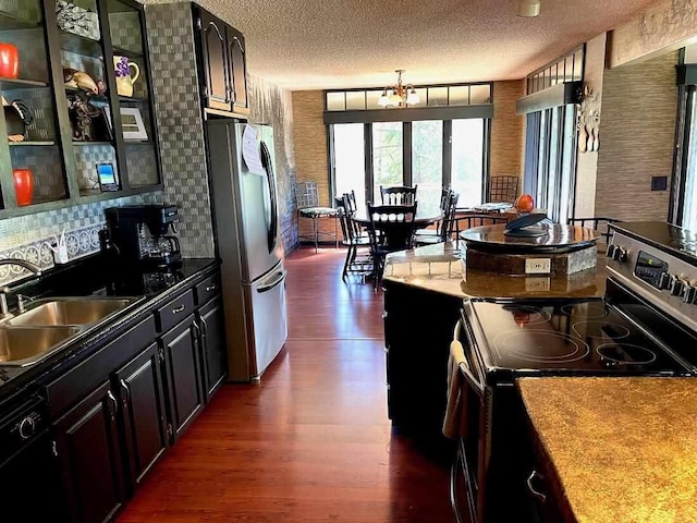 9690 Lake St, Ellsworth, MI 49729 - kitchen with appliances with stainless steel finishes, dark wood finished floors, a textured ceiling, a sink, and dark cabinetry