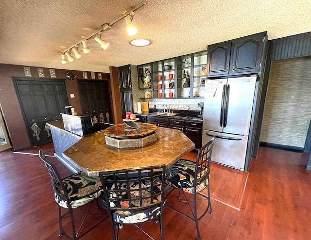 9690 Lake St, Ellsworth, MI 49729 - dining room with a textured ceiling, dark wood-type flooring, and rail lighting