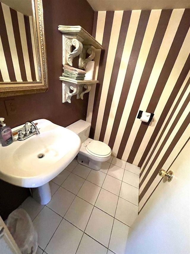9690 Lake St, Ellsworth, MI 49729 - bathroom with wallpapered walls, tile patterned floors, a sink, and toilet