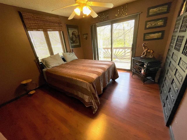 9690 Lake St, Ellsworth, MI 49729 - bedroom with access to exterior, wood finished floors, a textured ceiling, and a ceiling fan