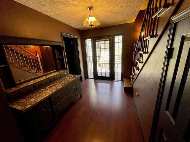 9690 Lake St, Ellsworth, MI 49729 - doorway with stairway, a textured ceiling, and dark wood-style flooring