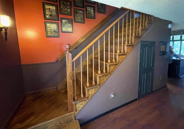 9690 Lake St, Ellsworth, MI 49729 - staircase with wood finished floors, baseboards, and a textured ceiling