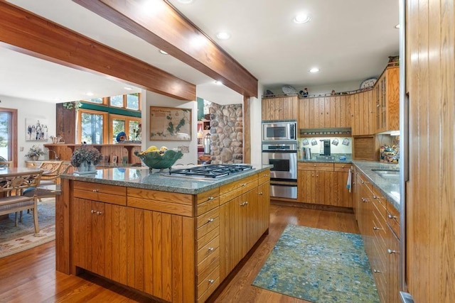 1442 Indian Point Rd, Brutus, MI 49716 - kitchen with stainless steel appliances, a warming drawer, beamed ceiling, a kitchen island, and wood finished floors