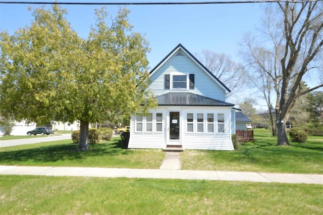 view of front facade featuring a front lawn, metal roof, and entry steps