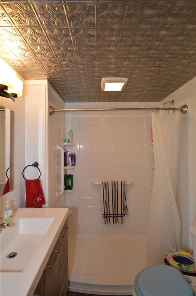 bathroom featuring vanity, an ornate ceiling, and toilet