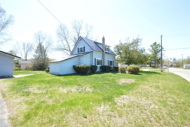 view of home's exterior with a chimney and a lawn