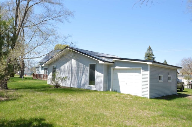 view of side of home featuring a yard and a garage