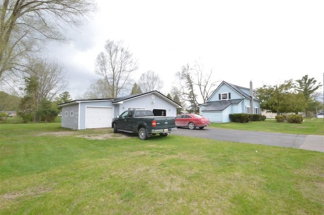 view of front facade featuring asphalt driveway, a front lawn, and a garage