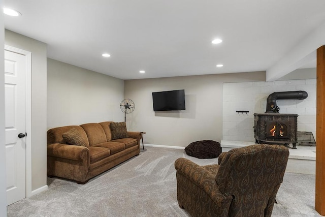 living room with carpet flooring, recessed lighting, baseboards, and a wood stove