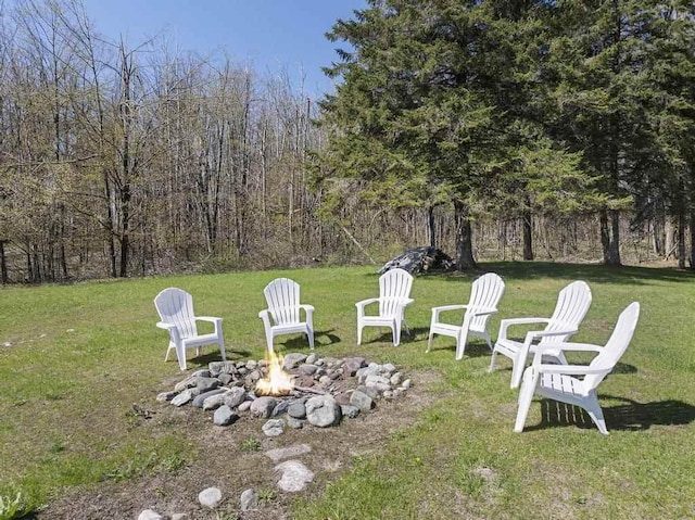 view of green lawn with a fire pit
