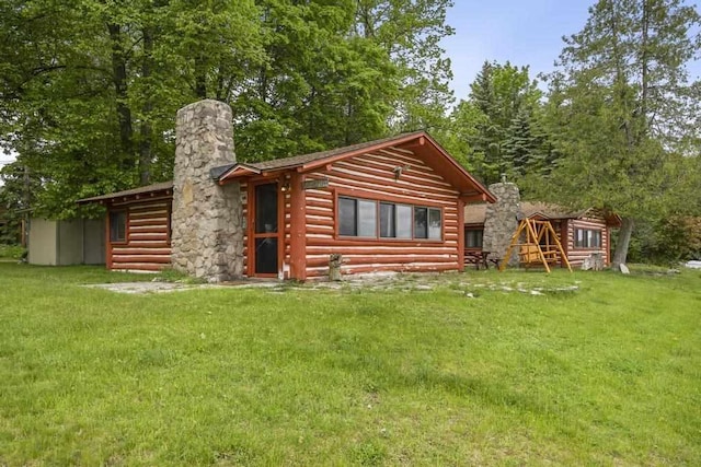1400 Michigan Ave, East Jordan, MI 49727 - rear view of property with a chimney, a lawn, and log veneer siding