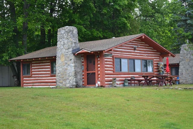 1400 Michigan Ave, East Jordan, MI 49727 - log home featuring a chimney, a front yard, and roof with shingles