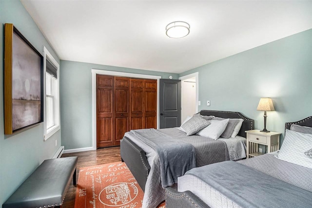 3190 Spring Dr, Boyne Falls, MI 49713 - bedroom with a closet, wood finished floors, a baseboard heating unit, and baseboards