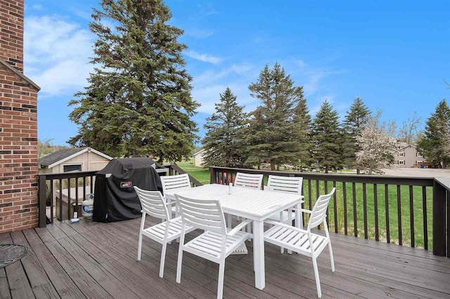 3190 Spring Dr, Boyne Falls, MI 49713 - wooden terrace with outdoor dining area, a lawn, and a grill