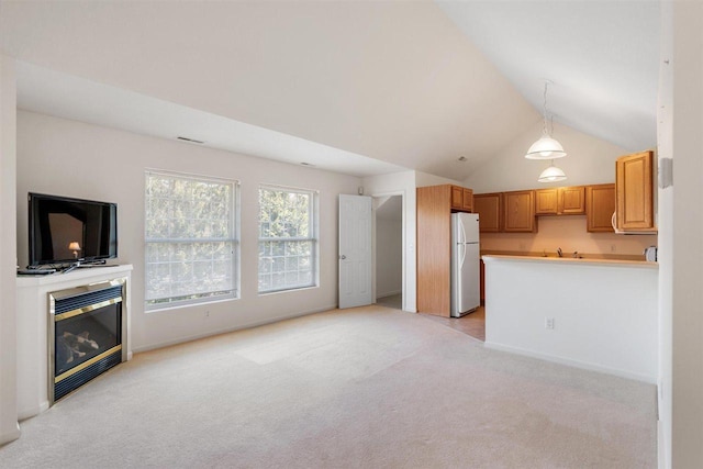 4070 Carriage House Dr Unit 5 & 6, Bay Harbor, MI 49770 - unfurnished living room featuring light carpet, lofted ceiling, and a glass covered fireplace