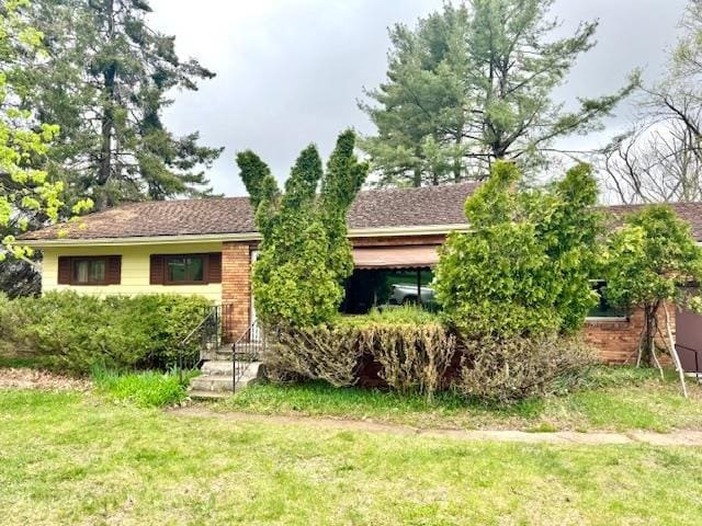 312 Sunset Rd, Petoskey, MI 49770 - view of front of home featuring a front yard and brick siding