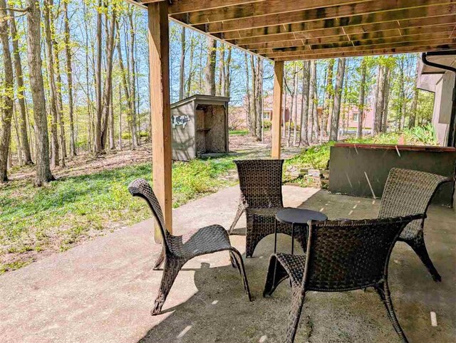 5350 Golfview Rd, Bellaire, MI 49615 - view of patio / terrace with a storage unit, an outbuilding, and outdoor dining area