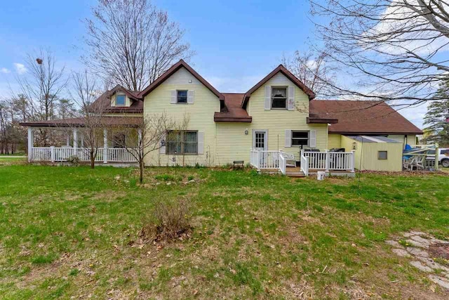 512 NW Kalkaska St, Kalkaska, MI 49646 - back of house featuring a yard, a shed, an outbuilding, a wooden deck, and covered porch