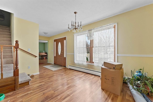 512 NW Kalkaska St, Kalkaska, MI 49646 - foyer featuring a baseboard radiator, stairway, wood finished floors, a chandelier, and baseboards