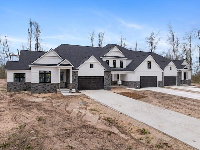 modern inspired farmhouse featuring stone siding, concrete driveway, and a garage