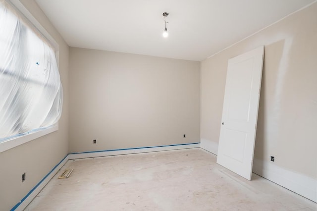 empty room featuring plenty of natural light and baseboards