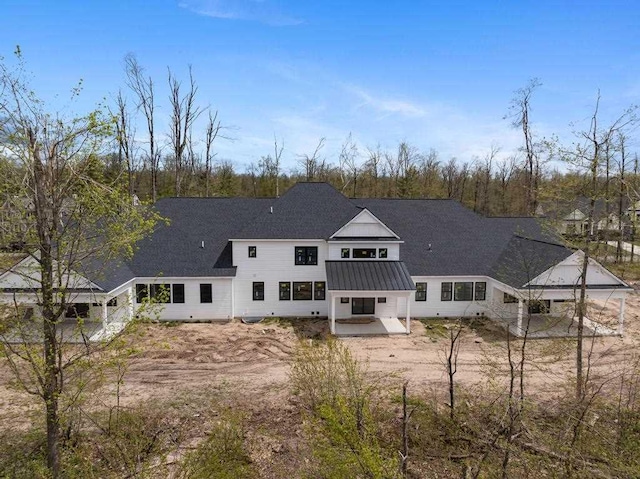 rear view of property with a patio and metal roof