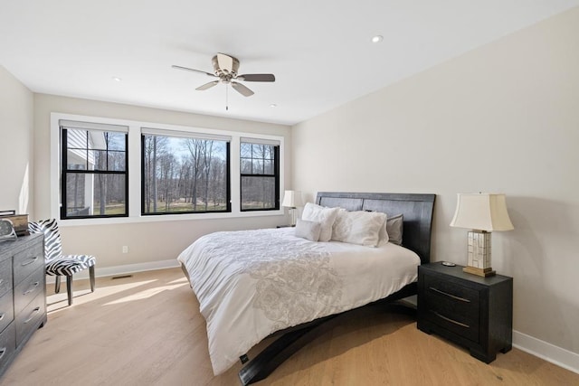 bedroom with baseboards, light wood-type flooring, a ceiling fan, and recessed lighting