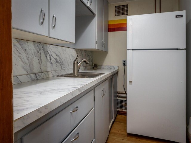 998 N Shr, Walloon Lake, MI 49796 - kitchen featuring freestanding refrigerator, decorative backsplash, light countertops, and gray cabinets