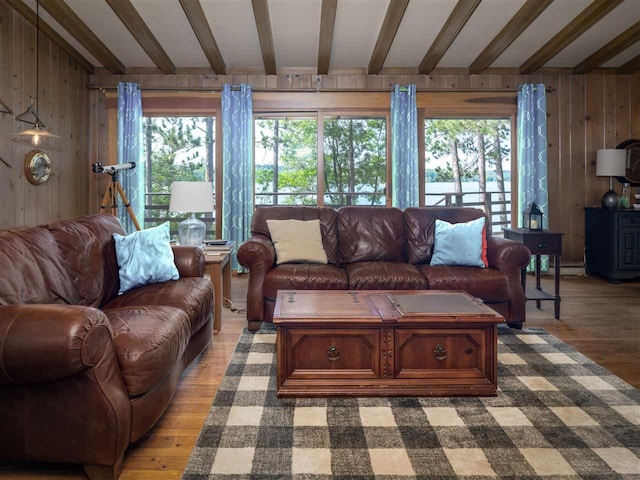 998 N Shr, Walloon Lake, MI 49796 - living area with beamed ceiling, wooden walls, healthy amount of natural light, and wood finished floors
