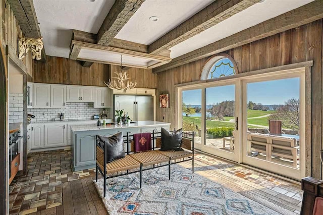 110 Birchwood Dr, Harbor Springs, MI 49740 - kitchen with high quality fridge, light countertops, a chandelier, wooden walls, and white cabinets