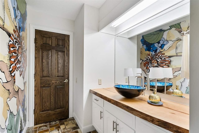 110 Birchwood Dr, Harbor Springs, MI 49740 - bathroom featuring vanity, baseboards, and stone finish flooring