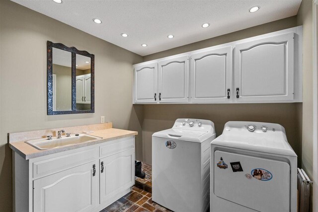 110 Birchwood Dr, Harbor Springs, MI 49740 - clothes washing area with washing machine and dryer, recessed lighting, cabinet space, dark stone finish floors, and a textured ceiling