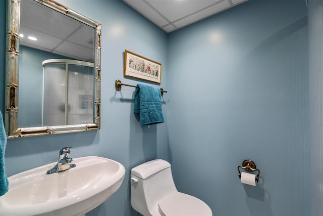 110 Birchwood Dr, Harbor Springs, MI 49740 - bathroom featuring a sink, a shower stall, a paneled ceiling, and toilet