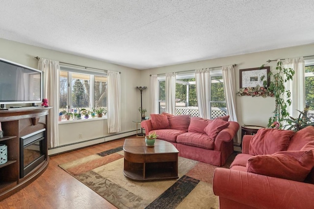 6141 S Old 31, Charlevoix, MI 49720 - living area with a baseboard heating unit, a textured ceiling, and wood finished floors