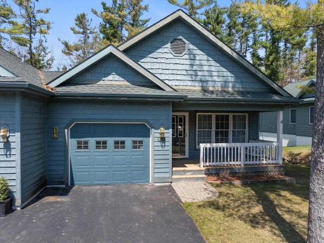 12175 Cottage Ln Unit 2, Charlevoix, MI 49720 - view of front facade featuring an attached garage, a porch, asphalt driveway, and roof with shingles