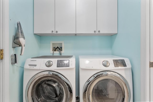 12175 Cottage Ln Unit 2, Charlevoix, MI 49720 - clothes washing area featuring washing machine and dryer and cabinet space