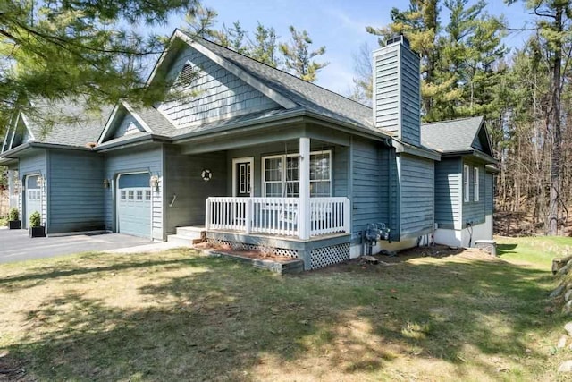 12175 Cottage Ln Unit 2, Charlevoix, MI 49720 - view of front facade featuring a porch, an attached garage, a chimney, a front yard, and a shingled roof