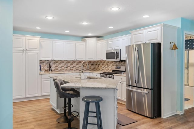 12175 Cottage Ln Unit 2, Charlevoix, MI 49720 - kitchen with appliances with stainless steel finishes, a sink, white cabinets, and recessed lighting