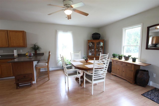4155 Welsch Rd, Petoskey, MI 49770 - dining space featuring healthy amount of natural light, light wood-style flooring, ceiling fan, and a baseboard heating unit