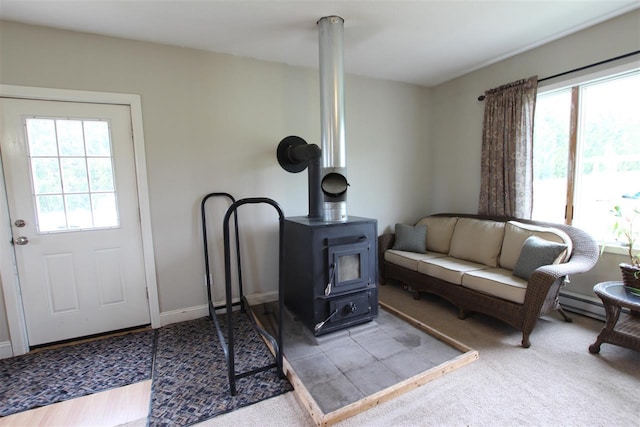 4155 Welsch Rd, Petoskey, MI 49770 - living area featuring a wood stove, healthy amount of natural light, and carpet floors