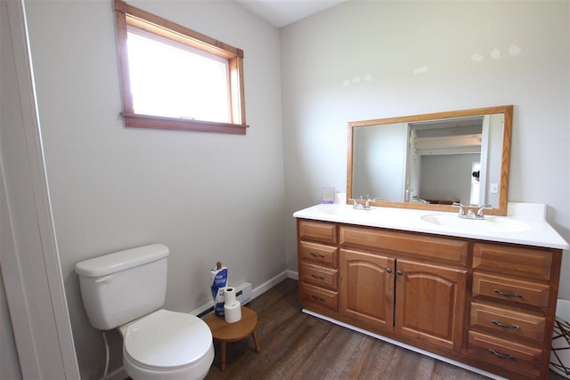 4155 Welsch Rd, Petoskey, MI 49770 - bathroom featuring wood finished floors, toilet, double vanity, and baseboards