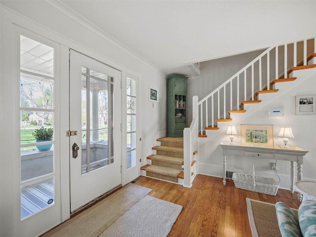 402 E Dixon Ave, Charlevoix, MI 49720 - entrance foyer with stairway, wood finished floors, crown molding, and baseboards