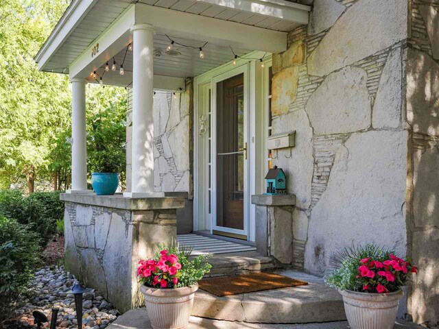 402 E Dixon Ave, Charlevoix, MI 49720 - doorway to property featuring stone siding and a porch