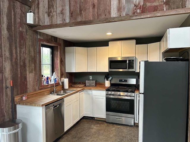 1645 Riley Rd, Kalkaska, MI 49646 - kitchen featuring stainless steel appliances, a sink, white cabinetry, and butcher block counters
