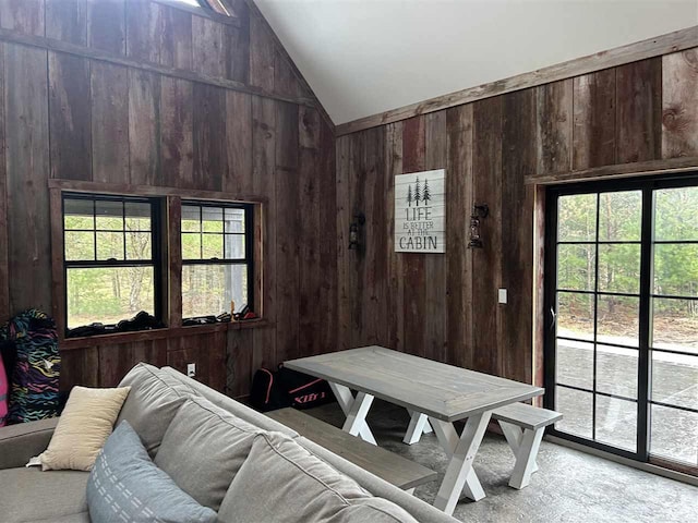 1645 Riley Rd, Kalkaska, MI 49646 - dining room with wood walls, lofted ceiling, and plenty of natural light