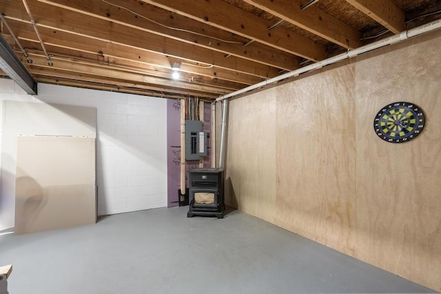 8900 Lewis Rd, Vanderbilt, MI 49795 - below grade area featuring electric panel and a wood stove