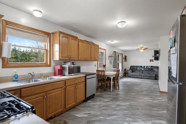 8900 Lewis Rd, Vanderbilt, MI 49795 - kitchen with stainless steel appliances, a sink, open floor plan, light countertops, and ceiling fan